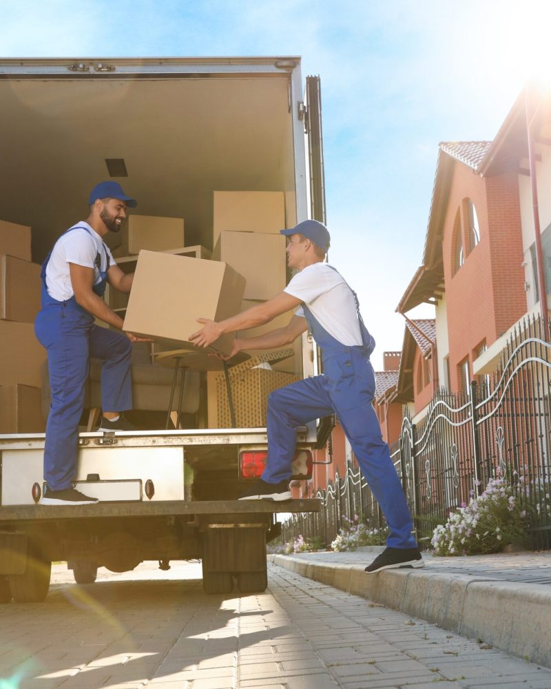 Workers,Unloading,Boxes,From,Van,Outdoors.,Moving,Service